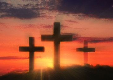 Image of Silhouette of Christian crosses outdoors at sunset