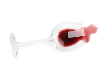 Photo of Transparent glass and spilled exquisite red wine on white background, top view