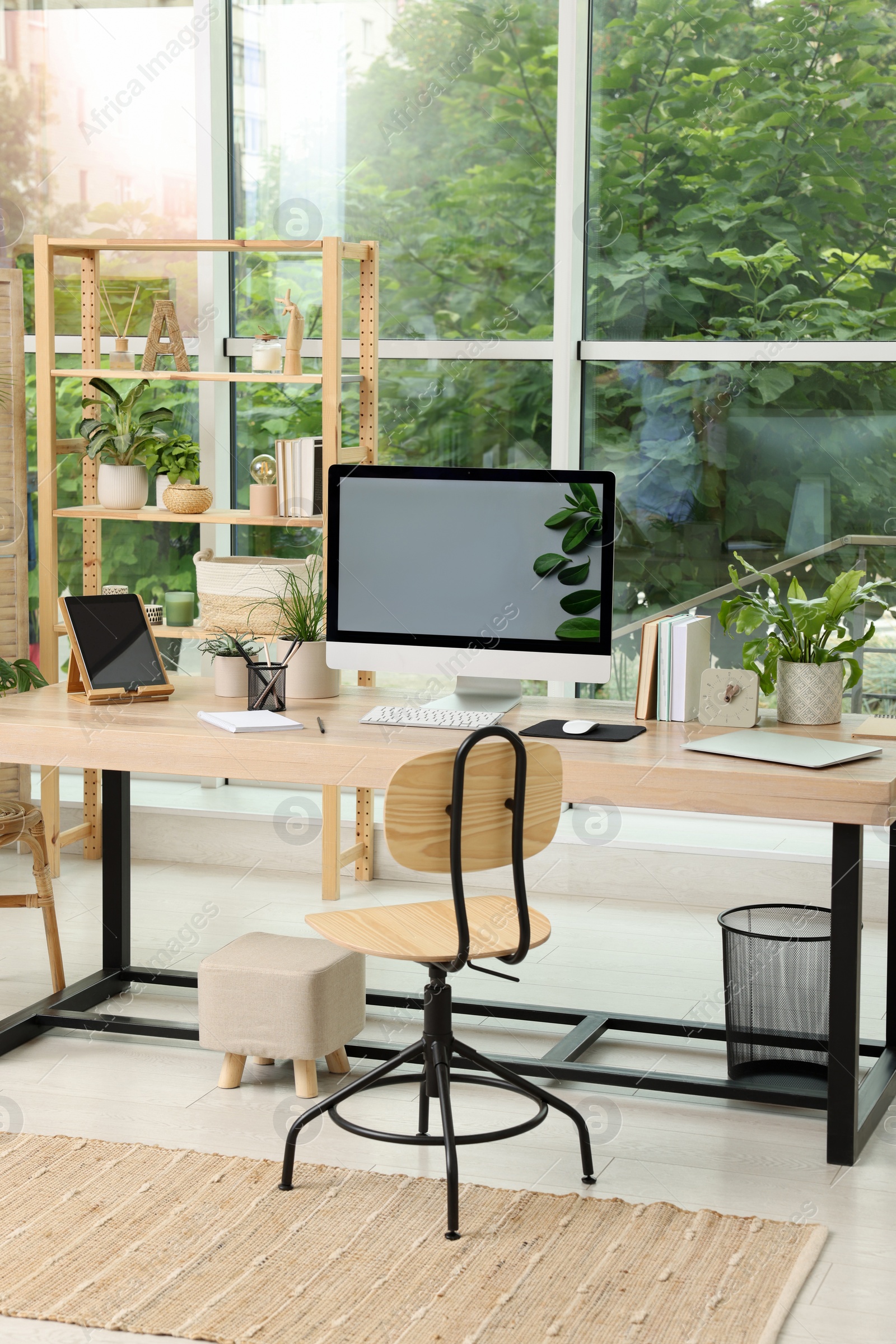 Photo of Comfortable workplace with computer in light room. Interior design