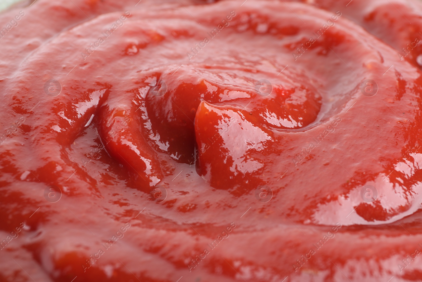 Photo of Tasty ketchup as background, closeup. Tomato sauce