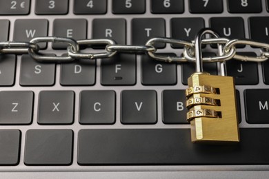 Photo of Cyber security. Padlock with chain on laptop, above view