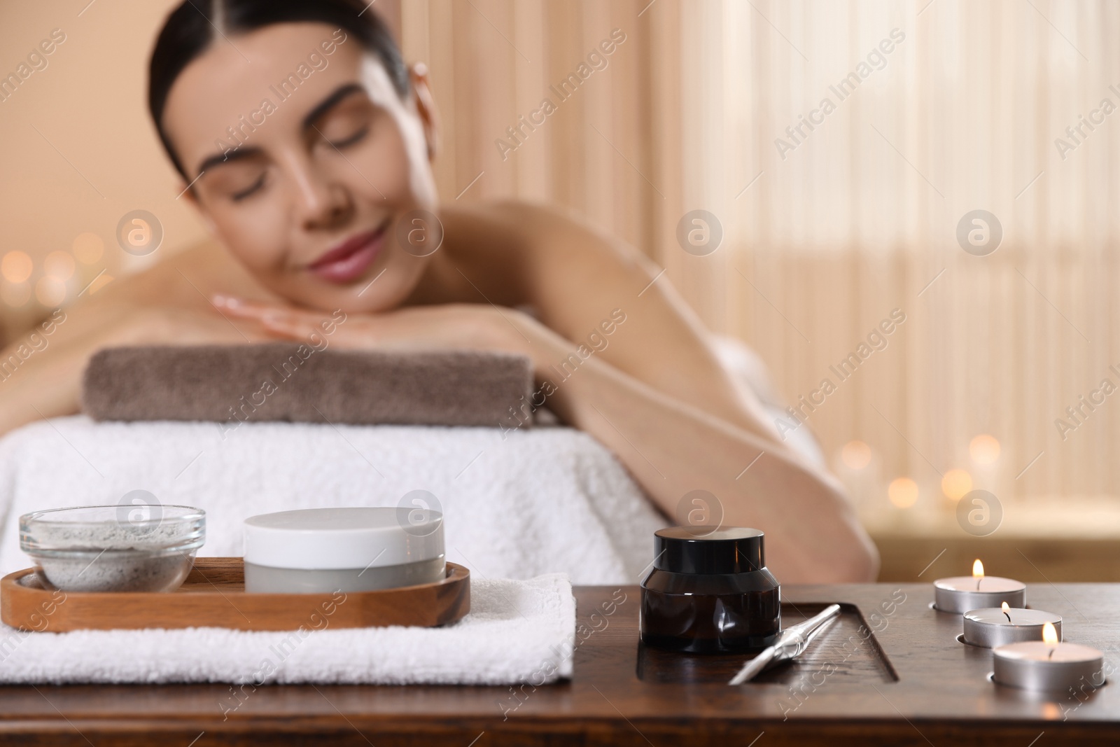 Photo of Young woman resting on massage couch in spa salon, selective focus. Space for text