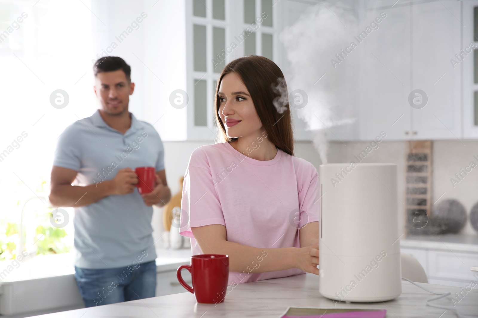 Photo of Couple in kitchen with modern air humidifier