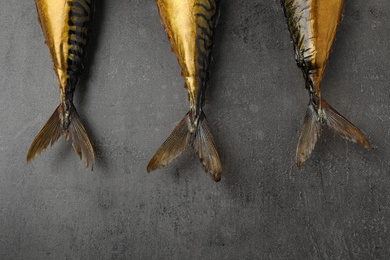 Photo of Tasty golden smoked fish on grey table, flat lay