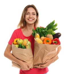 Photo of Young woman with bags of fresh vegetables isolated on white