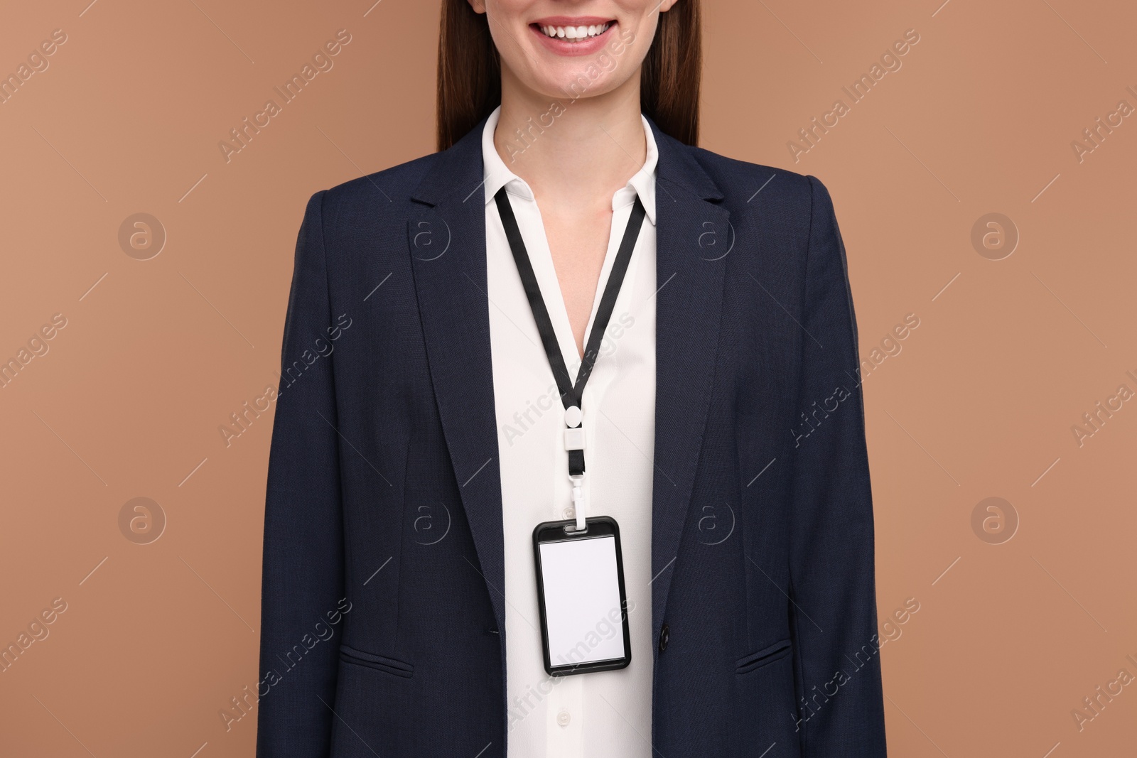 Photo of Woman with blank badge on light brown background, closeup