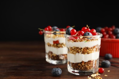 Photo of Delicious yogurt parfait with fresh berries on wooden table, space for text