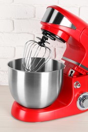 Photo of Modern red stand mixer on white wooden table