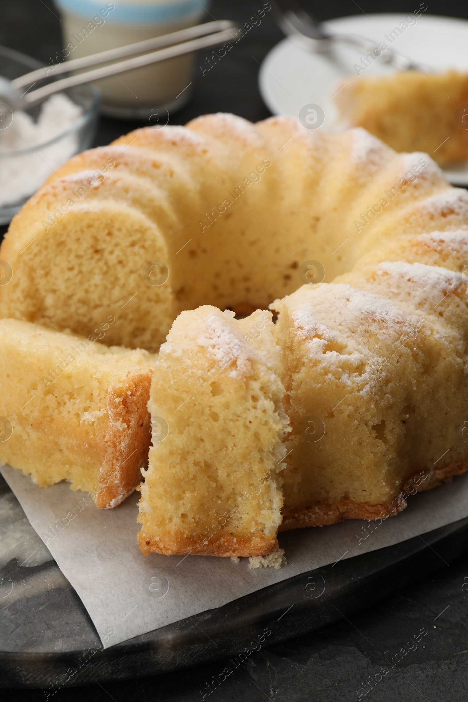 Photo of Delicious freshly baked sponge cake on black table, closeup