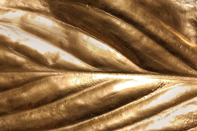 Photo of Closeup view of golden leaf as background
