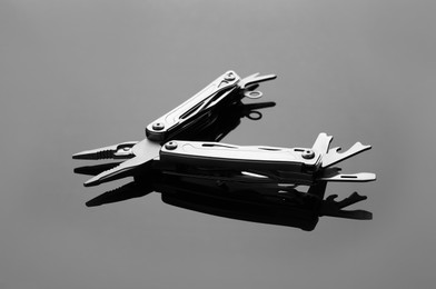 Photo of Compact portable metallic multitool on grey table