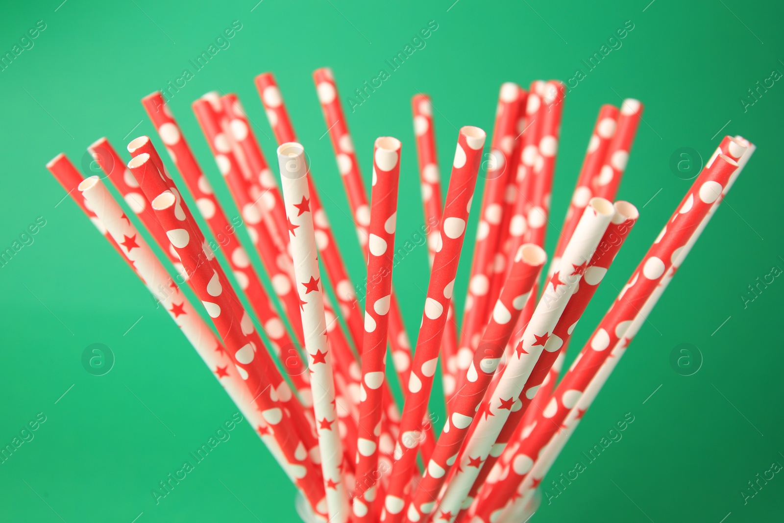 Photo of Many paper drinking straws on green background