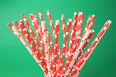 Many paper drinking straws on green background