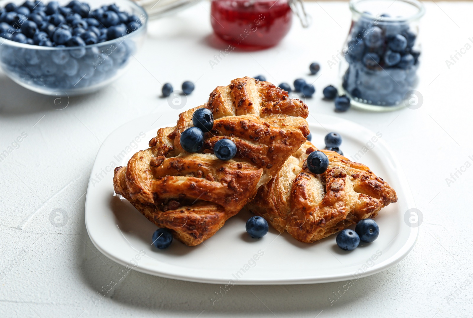 Photo of Fresh delicious puff pastry with sweet berries served on grey table