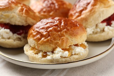 Photo of Freshly baked soda water scones with cranberry jam and butter on table, closeup