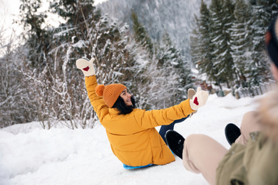 Couple having fun and sledding on snow. Winter vacation