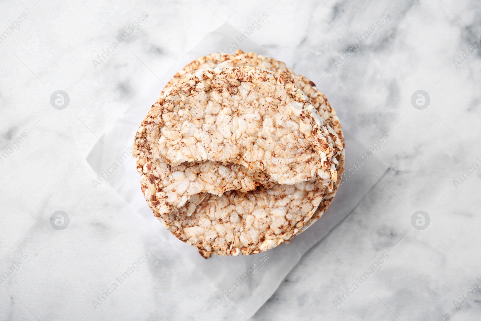 Photo of Stack of crunchy buckwheat cakes on white marble table, top view