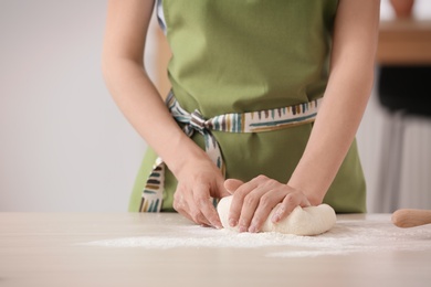 Photo of Woman kneading fresh dough on table, closeup