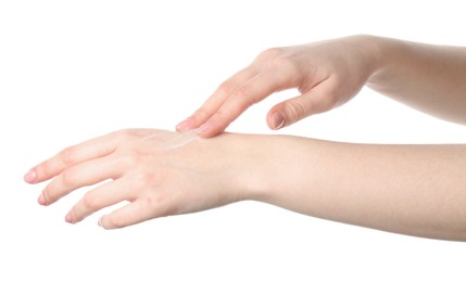 Woman applying cream on her hand against white background, closeup