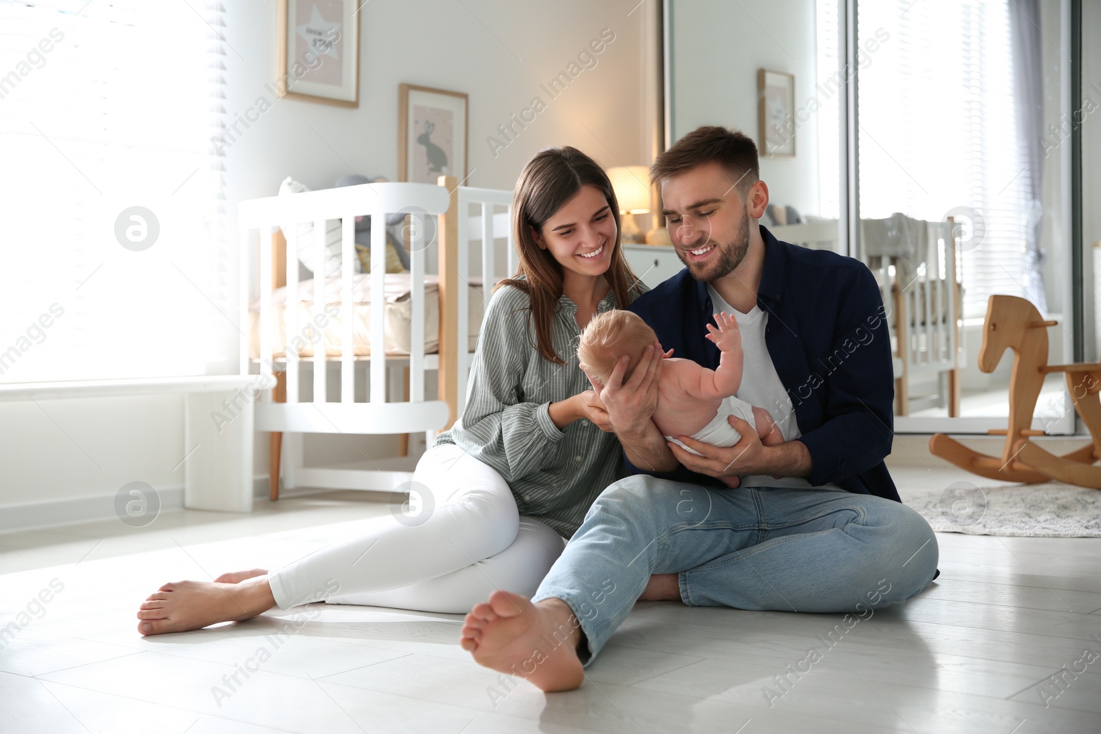 Photo of Happy couple with their newborn baby at home