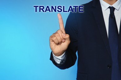Image of Man pointing at virtual model of word TRANSLATE against turquoise background, closeup