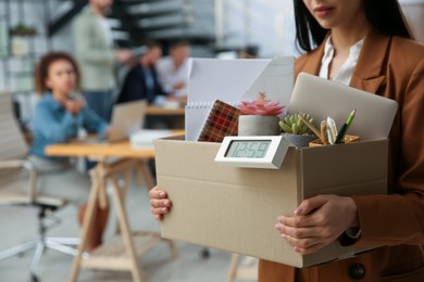 Photo of Young dismissed woman carrying box with stuff in office, closeup. Space for text