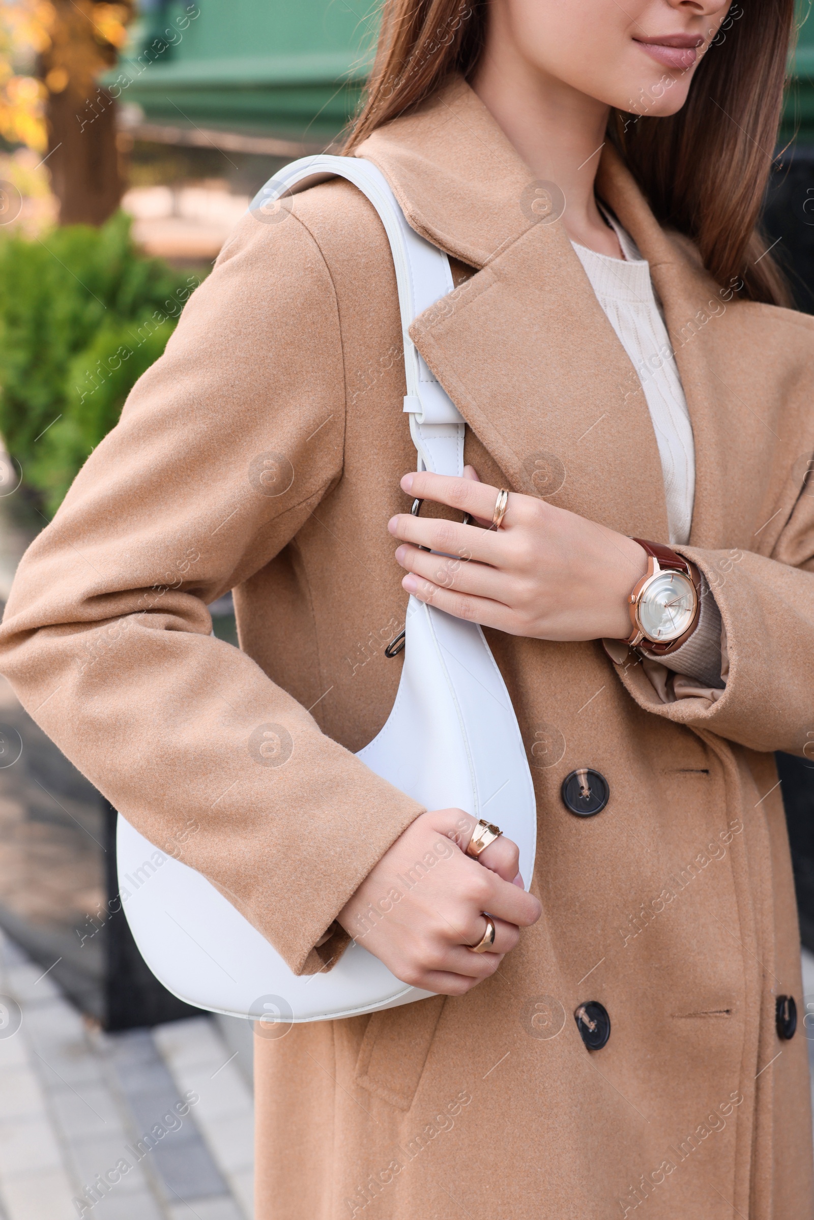 Photo of Fashionable young woman with stylish bag on city street, closeup