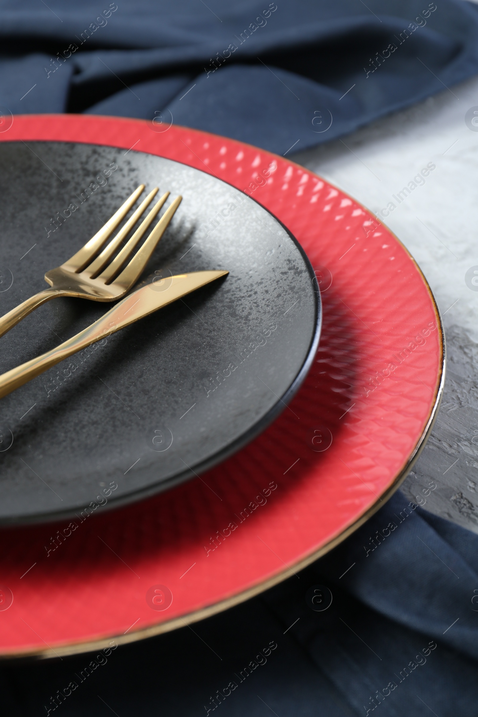 Photo of Elegant ceramic plates and cutlery on light table, closeup