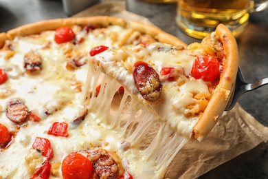 Photo of Shovel with slice of delicious hot pizza over table, closeup