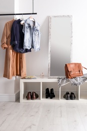 Modern hallway interior with hanging clothes and shoe rack