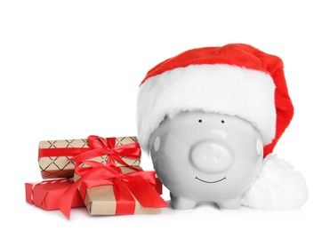 Cute piggy bank with Santa hat and Christmas gifts on white background