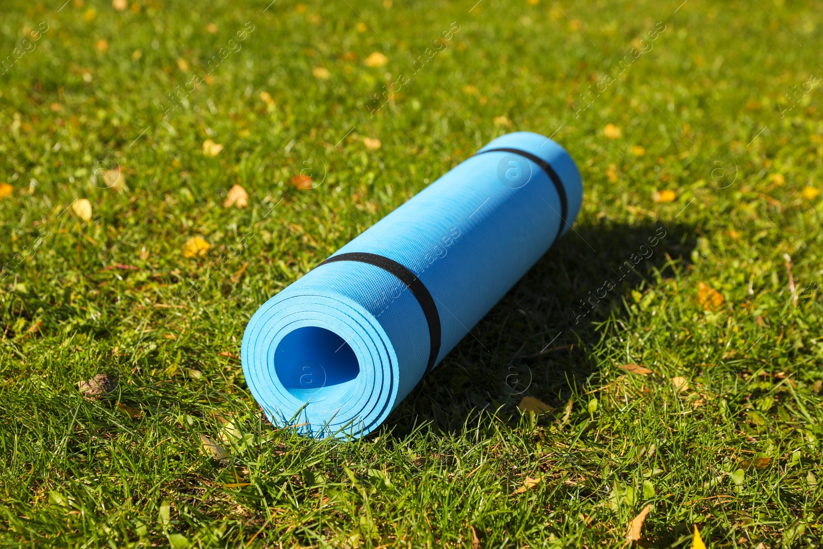 Photo of Blue karemat or fitness mat on fresh green grass outdoors