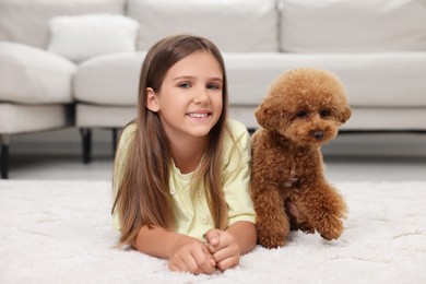 Photo of Little child and cute puppy on carpet at home. Lovely pet