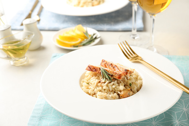 Photo of Delicious chicken risotto with rosemary served on table