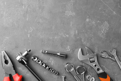 Photo of Auto mechanic's tools on grey stone table, flat lay. Space for text