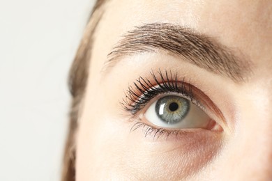 Macro photo of woman with beautiful eyes on light background