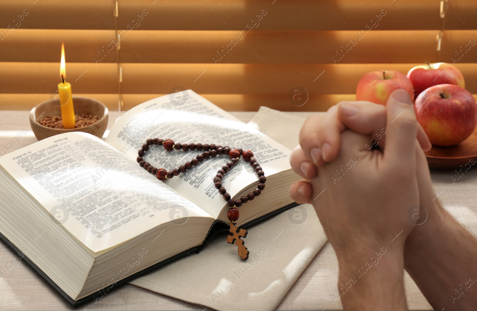 Photo of Man with Bible praying near window indoors, closeup. Great Lent season