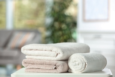 Photo of Clean soft terry towels on table indoors