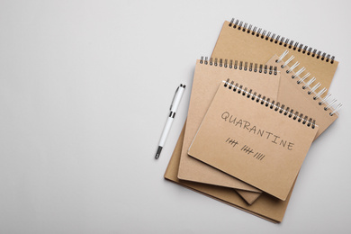 Image of Notebooks and pen on light background, top view with space for text. Counting days of quarantine during coronavirus outbreak