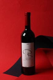 Photo of Bottle of delicious red wine on color background