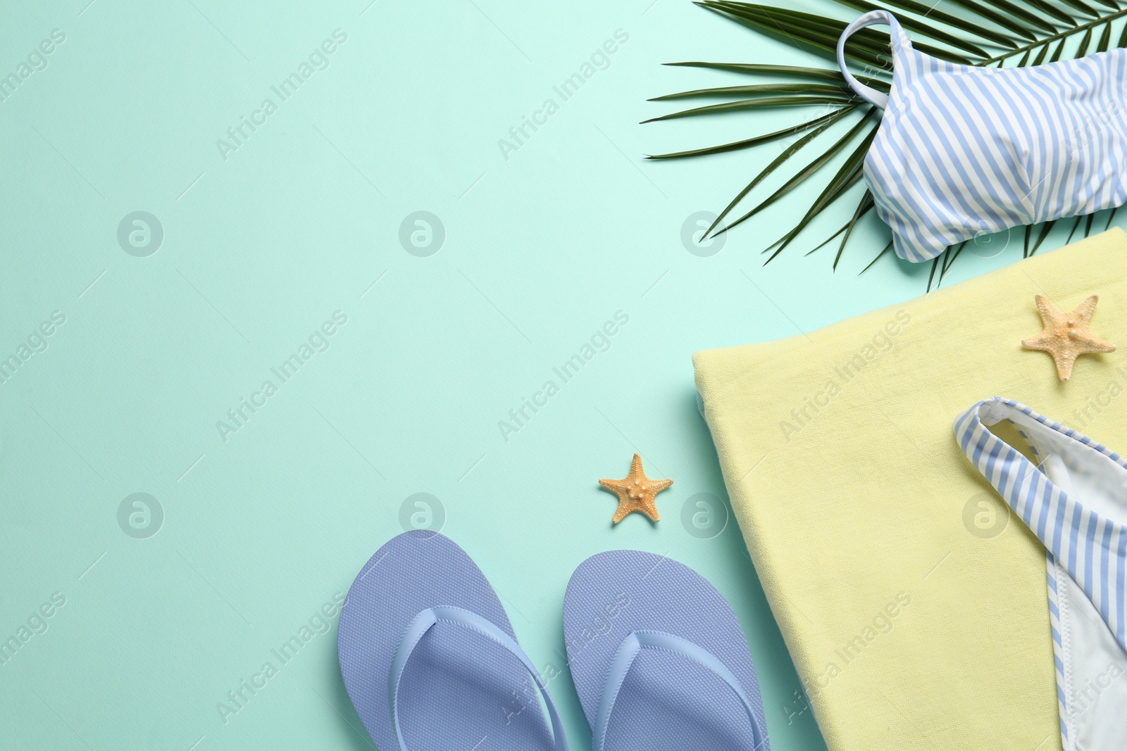 Photo of Flat lay composition with different beach objects on light blue background, space for text