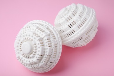 Photo of Dryer balls for washing machine on pink background, closeup. Laundry detergent substitute
