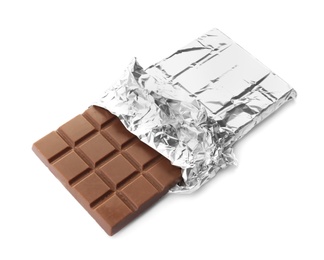 Photo of Delicious milk chocolate bar in foil on white background