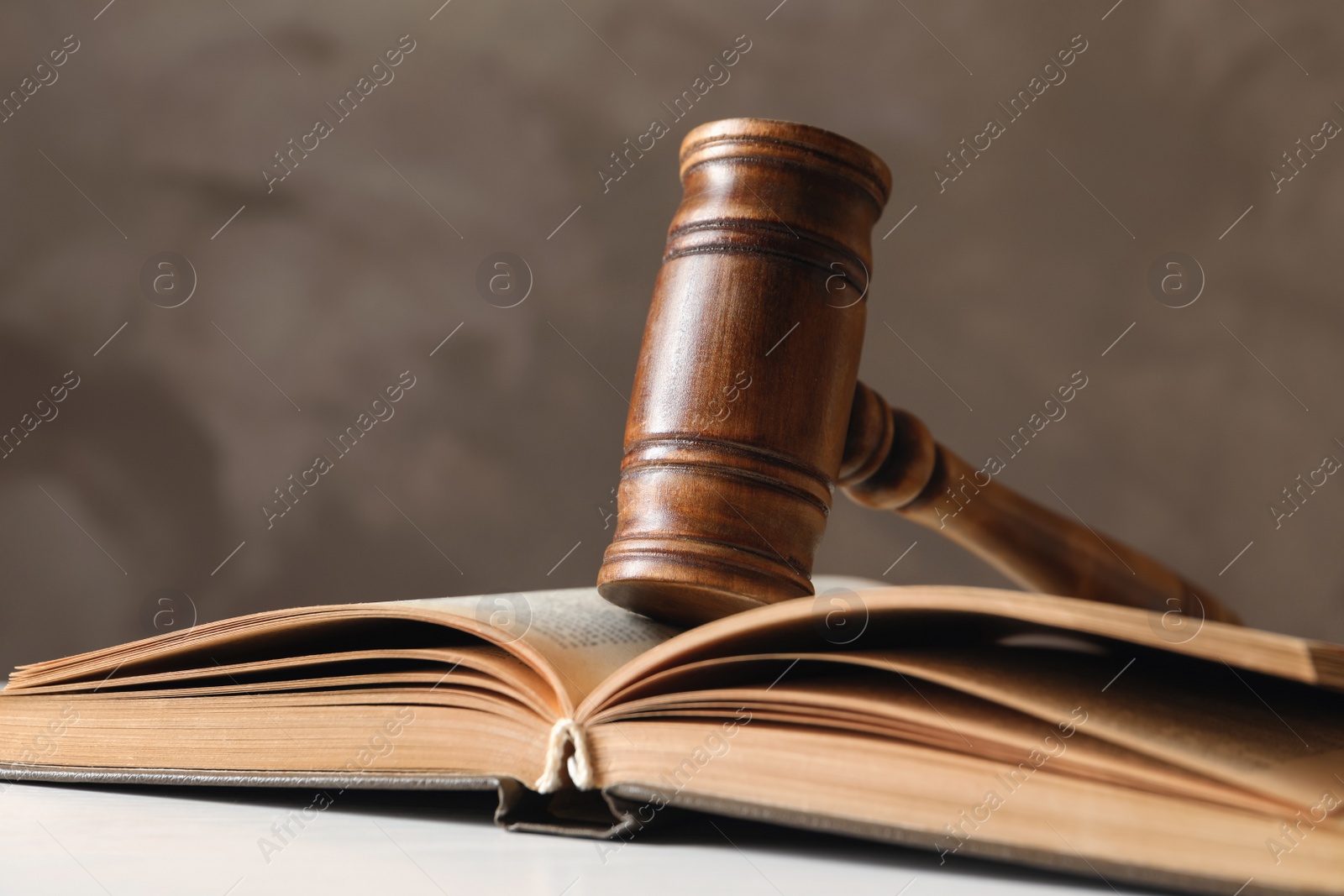 Photo of Wooden gavel and book on table against color background, closeup. Law concept