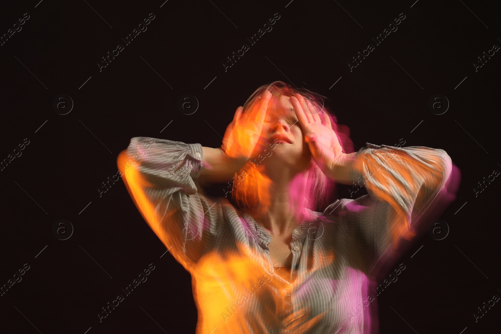 Photo of Young woman performing contemporary dance on black background, motion blur effect