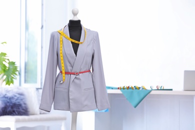 Mannequin with jacket and measuring tape in tailor studio