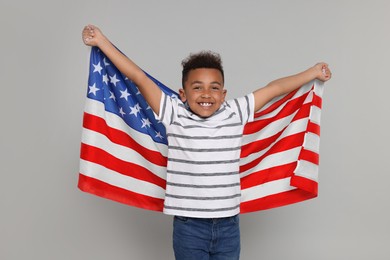 Photo of 4th of July - Independence Day of USA. Happy boy with American flag on light grey background