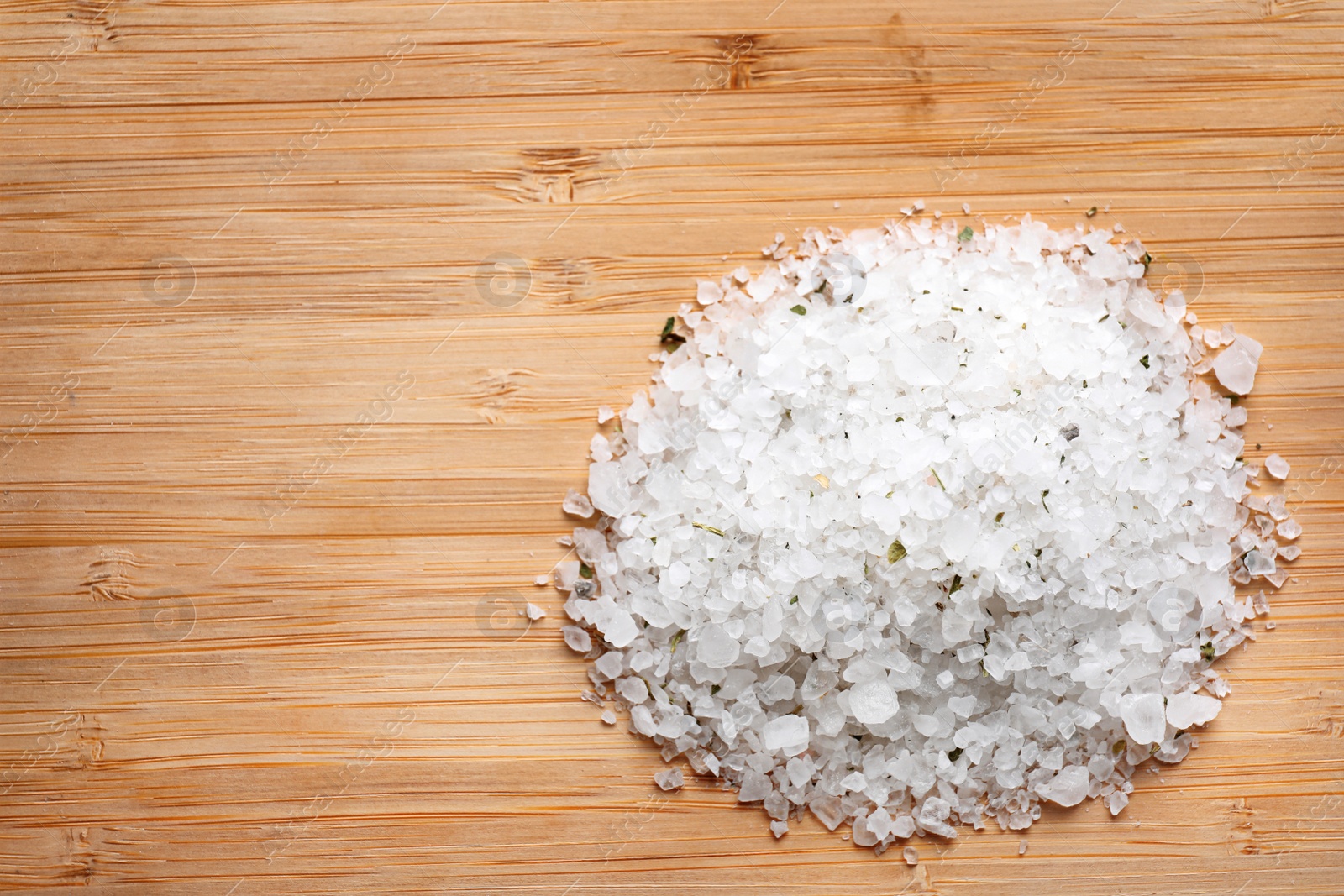 Photo of Pile of white sea salt on wooden table, top view with space for text. Spa treatment