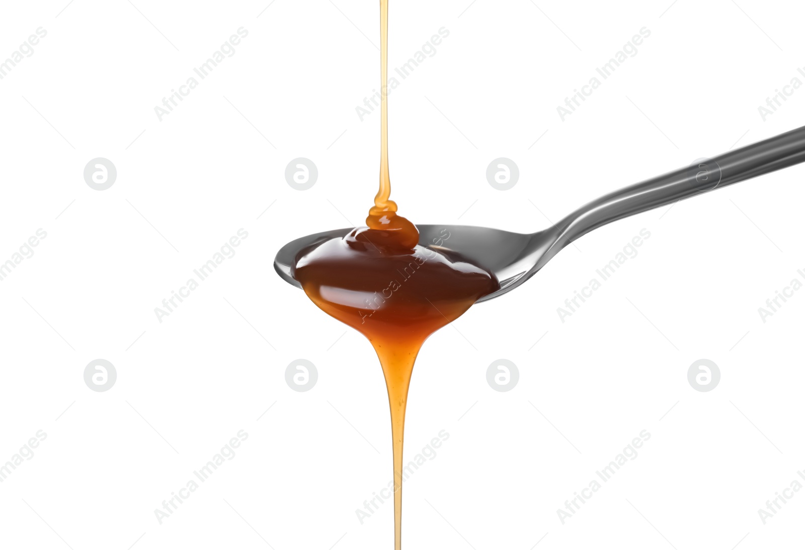 Photo of Pouring salted caramel into spoon isolated on white