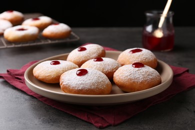 Hanukkah donuts with jelly and powdered sugar on grey table